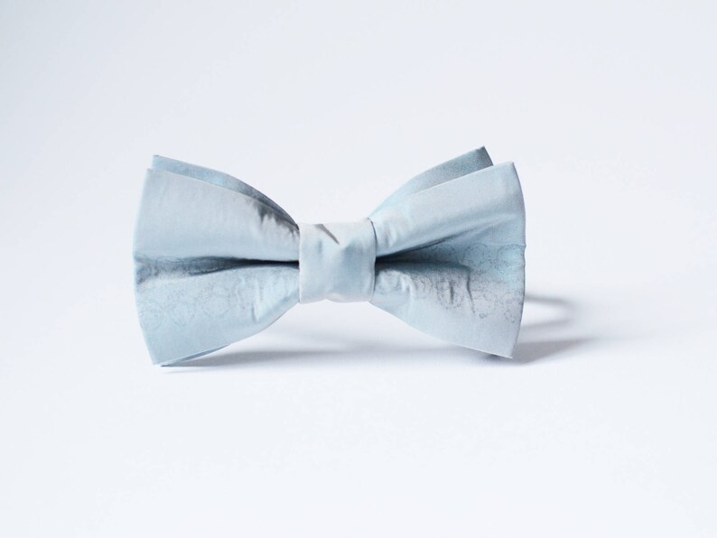 Peut inclure: Un n&oelig;ud papillon bleu clair en tissu. Le n&oelig;ud papillon est nou&eacute; et pr&ecirc;t &agrave; &ecirc;tre port&eacute;.