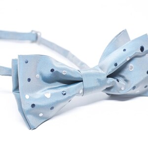 Peut inclure: Un n&oelig;ud papillon bleu clair avec un motif de pois blancs et bleus.