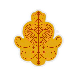 May include: A yellow sticker with a red heart-shaped design and a stylized tree with crosses and stars. The design is reminiscent of a traditional folk art style.
