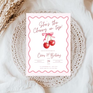 Puede incluir: Una tarjeta de invitación rosa y blanca con el texto "She's the Cherry on top!" y "Chloe's 21st Birthday". La tarjeta presenta una ilustración de acuarela de cerezas y un borde rosa festoneado. La fecha es el 29 de junio.