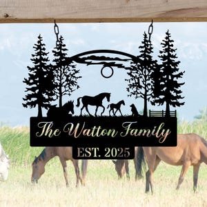 Könnte beinhalten: Schwarzes Metallschild für die Familie mit Silhouetten von Pferden, Bäumen und einem Hund. Auf dem Schild steht "The Watton Family" mit "EST. 2025" darunter. Das Schild wird mit Ketten aufgehängt.