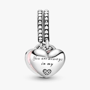 May include: A silver heart-shaped charm with the inscription "You are always in my" and a small cluster of clear stones. The charm has a pink interior and hangs from a decorative silver bail.