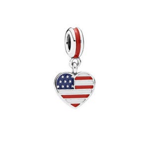 Puede incluir: Un charm de plata con un colgante en forma de corazón que representa la bandera estadounidense. El charm tiene rayas rojas y blancas y un campo azul con estrellas blancas. El lazo superior es rojo y plateado.