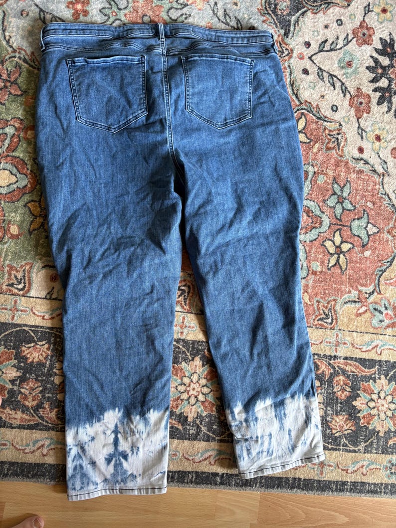 K&ouml;nnte beinhalten: Blaue Jeans mit einem Batik-Design an den Manschetten. Die Jeans hat zwei Ges&auml;&szlig;taschen und ein klassisches F&uuml;nf-Taschen-Design. Die Jeans hat eine mittlere Waschung und scheint eine entspannte Passform zu haben.