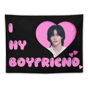 May include: Black tapestry with the text "I MY BOYFRIEND" in pink bubble letters. A pink heart shape contains a photo of a person with dark hair. Two small pink hearts are in the lower right corner.