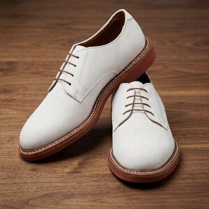 Peut inclure: Une paire de chaussures richelieu blanches avec une finition mate lisse, des lacets marron fins et une semelle marron épaisse et superposée avec des coutures visibles le long de la trépointe. Elles présentent un bout arrondi et une coupe basse.