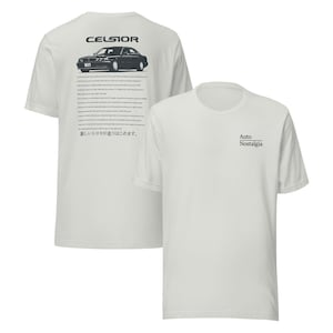 May include: Two white t-shirts. One shirt has a black graphic of a car with the word "CELSIOR" above it and text below. The other shirt has the words "Auto Nostalgia" printed on the front.