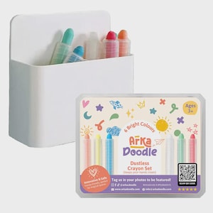 May include: A white plastic container holding several colorful crayons. A package of six bright-colored dustless crayons is displayed next to the container. The crayon set is labeled "Arka Doodle" and is suitable for ages 3+.