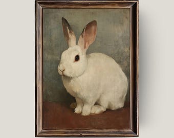 May include: A framed vintage-style painting of a white rabbit with long ears and dark eyes. The rabbit is sitting on a red surface against a muted blue-green background. The frame is a dark, warm brown.