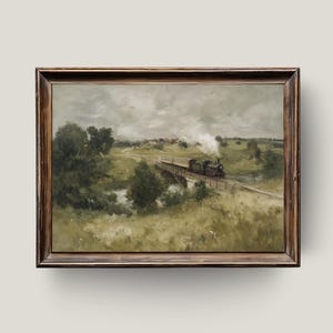 May include: A framed landscape painting depicts a train crossing a bridge over a river. The artwork features a steam train, green fields, trees, and a cloudy sky. The painting is in a wooden frame.