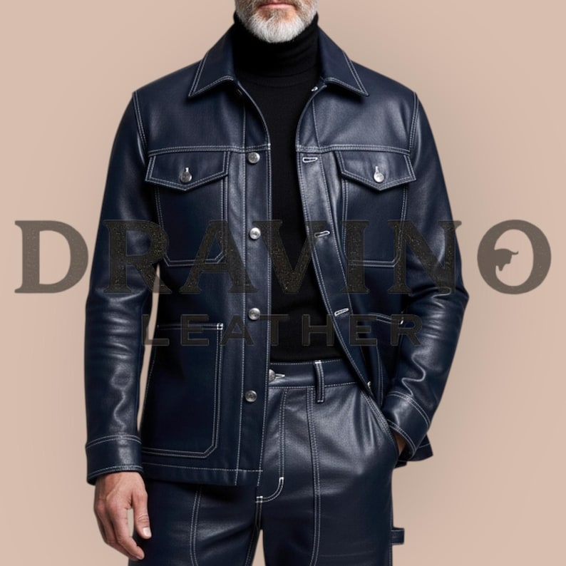 May include: Navy blue leather jacket and matching pants with white stitching. The jacket has two chest pockets and a button-up front. The pants have a straight leg design. The text "DRAMINO LEATHER" is visible in the image.