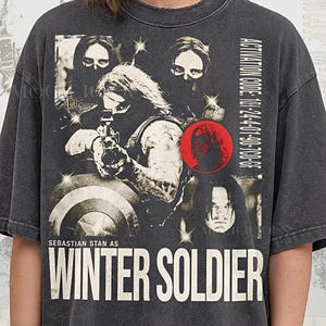 Puede incluir: Camiseta gris oscuro con un gráfico de Winter Soldier, el texto "WINTER SOLDIER" y "ACTIVATION CODE: 101-24-01-90-700-0F". También presenta "SEBASTIAN STAN AS" y "PEPPER COMFORT COLORS".