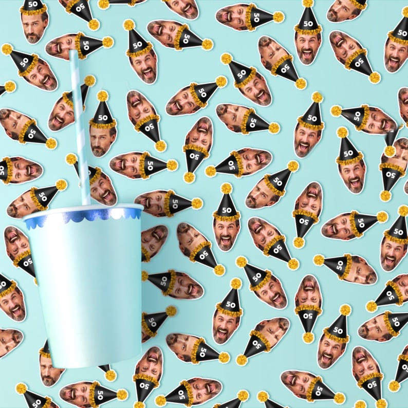 Puede incluir: Un vaso de papel azul claro con un borde azul y blanco y una pajita a rayas. El fondo es un patr&oacute;n de caras sonrientes con sombreros de fiesta negros con el n&uacute;mero "50" sobre un fondo azul claro.