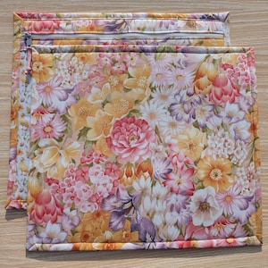 Puede incluir: Dos bolsas rectangulares de tela floral con cierre de cremallera. Las bolsas presentan un vibrante estampado de flores rosas, amarillas y moradas. Los bordes est&aacute;n cuidadosamente cosidos y la cremallera es de color beige claro. Las bolsas est&aacute;n dise&ntilde;adas para guardar o organizar.