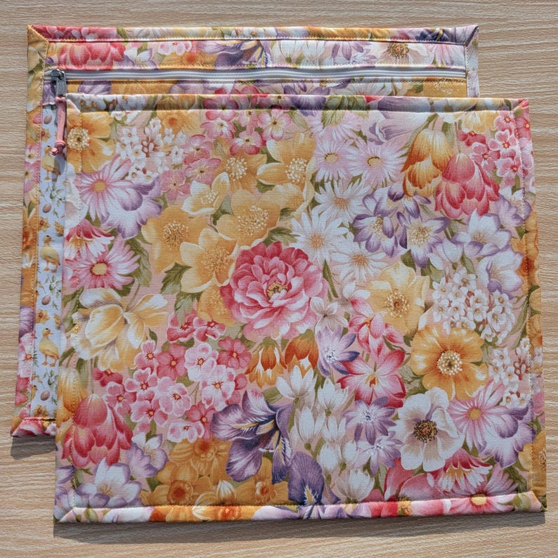 Puede incluir: Dos bolsas rectangulares de tela floral con cierre de cremallera. Las bolsas presentan un vibrante estampado de flores rosas, amarillas y moradas. Los bordes est&aacute;n cuidadosamente cosidos y la cremallera es de color beige claro. Las bolsas est&aacute;n dise&ntilde;adas para guardar o organizar.