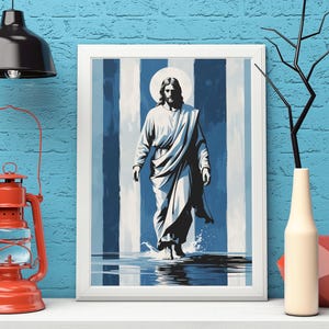 Puede incluir: Impresión artística enmarcada que representa una figura con túnica blanca y halo, caminando sobre el agua. El fondo presenta rayas verticales azules y blancas. La obra de arte se exhibe en una estante blanco con una linterna roja y una lámpara negra.