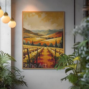 Puede incluir: Una impresión artística enmarcada que representa un paisaje de viñedos con hileras de vides, colinas y un cielo cálido. La obra de arte está etiquetada como "Boho Art" y se muestra en una pared gris.