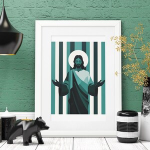 Puede incluir: Una impresión artística enmarcada que presenta una ilustración estilizada de Jesús con los brazos extendidos, sobre un fondo a rayas turquesa y blanco. La obra de arte se exhibe en un marco blanco, complementada con velas decorativas, una figura de oso y un jarrón.