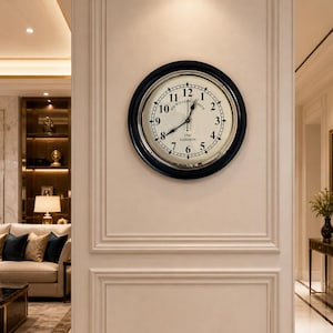 May include: A circular wall clock with a black surround and a cream-coloured face. It displays black Roman numerals and hands, with the text "Mr. William Smith 1747 London" at the base. The clock is mounted on a white wall.