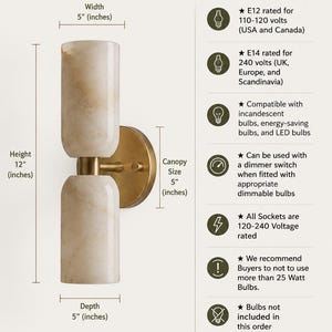 May include: Modern alabaster wall sconce with two cylindrical stone shades and a brass finish mount. Dimensions are 12 inches high, 5 inches wide, and 5 inches deep. Features E12 and E14 socket compatibility, dimmer switch support, and 25-watt bulb limit.