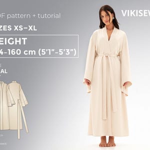 May include: A cream-coloured robe with a matching belt, worn by a person. The robe is part of a PDF pattern and tutorial, sizes XS-XL, for heights 154-160 cm (5'1"-5'3"). The pattern is labelled "ROBE AMAL" and is of intermediate difficulty. The brand is VIKISEWS.