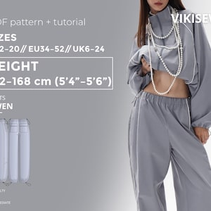 May include: A gray tracksuit with white trim is shown. The outfit includes a cropped jacket and high-waisted pants. The image also displays text indicating the pattern is for sizes US2-20, height 5'4"-5'6", and the difficulty level is intermediate.