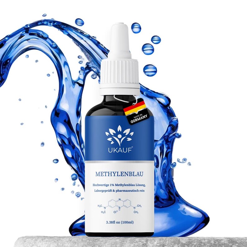 May include: A dark glass bottle with a white dropper top and a blue label. The label features the text "UKAUF" and "METHYLENBLAU". The bottle is 3.38 fl oz (100ml). A tag with the German flag and "MADE IN GERMANY" hangs from the bottle.