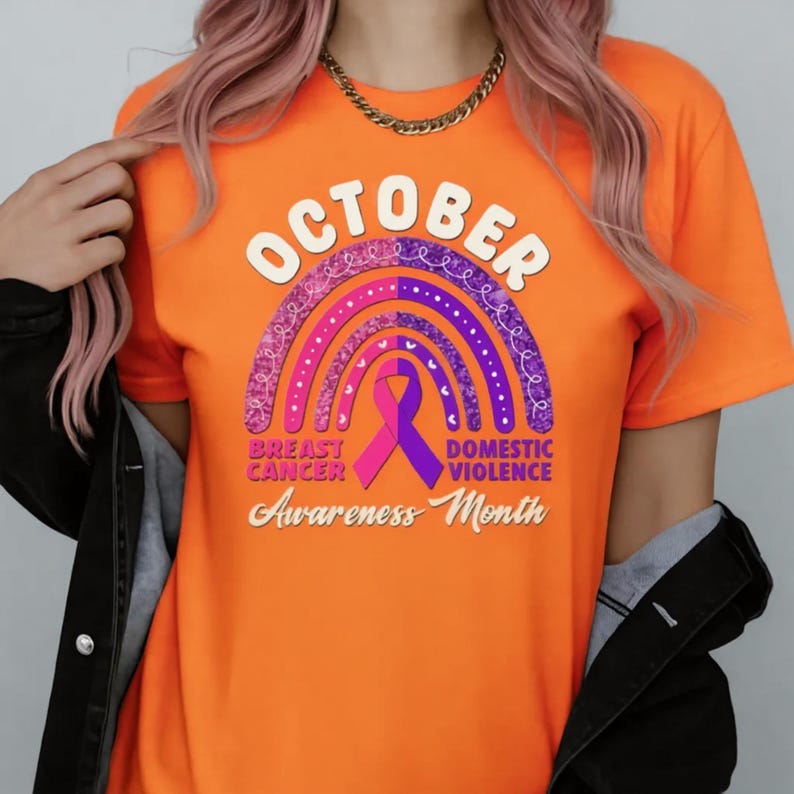 a person wearing an orange t-shirt with a graphic design related to breast cancer awareness.