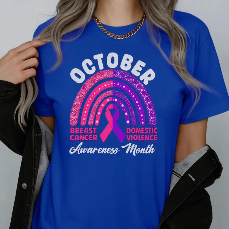 A person wearing a blue t-shirt with a graphic design related to breast cancer awareness.