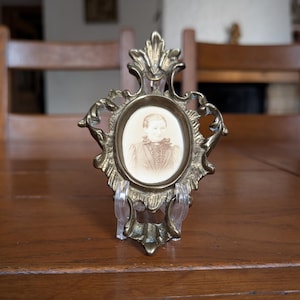 Antique Victorian brass photo frame with ornate rococo design and original sepia portrait from the 19th century as collectible home decor
