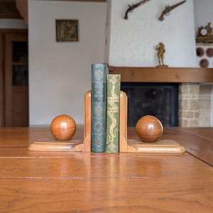 Pair of wooden bookends in modernist design with round ball detail as a gift for stylish home library or office bookshelf organization
