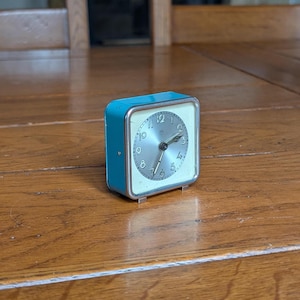 Junghans vintage square mechanical alarm clock in turquoise metal case with silver dial and black numerals from Germany