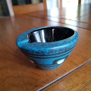 A vintage ceramic small ashtray for a single cigarette in blue color with ornamentation made mid-century in West Germany of the 70s