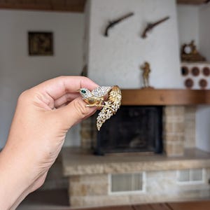 Vintage gold tone bird brooch with clear rhinestones perched on branch for elegant collector’s jewelry gift