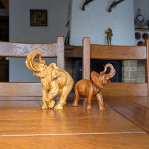 Vintage70s set of 2 elephants made of resin with detailed texture and raised trunks as a symbol of good luck for home decor