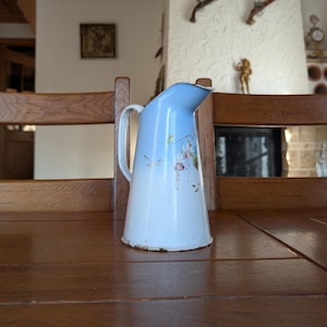 Vintage French enameled pitcher with blue and white gradient and hand-painted floral pattern for rustic country home decor