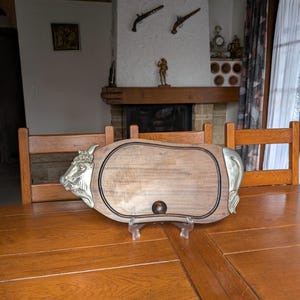 Vintage gastro wood meat cutting board with metal handles in the shape of a cow&#39;s head and tail for a mid-century rustic kitchen from France