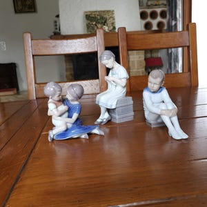 Royal Copenhagen collectible porcelain figurine of your choice – Boy on a Book #1742, Girl Knitting #1656, or Sister with Brother #1568