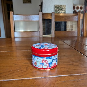 Vintage Christmas candy storage tin with red color and Santa motif