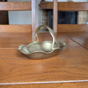 Vintage small brass decorative basket with ornate edge and curved handle for a Provence style table decoration