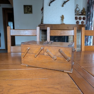 Vintage wooden sewing box with fold-out compartments in art deco style for rustic country home storage or craft room decoration