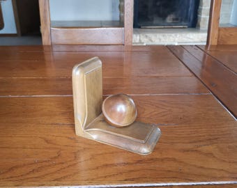 Sujetalibros vintage con esfera en madera con decoración art déco de mediados de siglo.