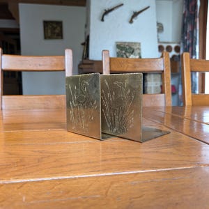 Vintage pair of large handmade brass book holders featuring a heron in the water as a gift for a book lover