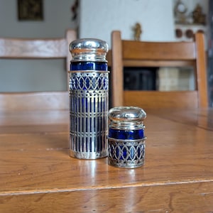 Vintage cobalt blue glass salt and pepper shakers set in ornate metal holders for retro kitchen decor