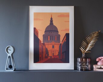 Puede incluir: Una impresión artística enmarcada que representa la Catedral de San Pablo en Londres, con un estilo minimalista y tonos cálidos de naranja y rojo. La impresión se exhibe en una estantería gris oscuro, junto con un reloj moderno, un jarrón decorativo y un teléfono rosa vintage.