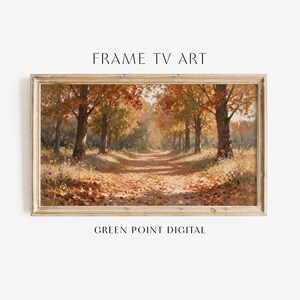 Peut inclure: Une œuvre d'art numérique rectangulaire pour téléviseur cadre représentant une peinture à l'huile d'un chemin forestier automnal avec un feuillage orange et brun, dans un cadre en bois clair. Le texte FRAME TV ART et GREEN POINT DIGITAL est visible.