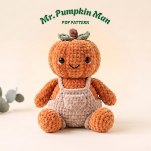 May include: A crocheted orange pumpkin doll with a brown stem and green leaves, wearing beige overalls. The text Mr. Pumpkin Man PDF PATTERN is displayed above the doll, which has black eyes and a stitched smile on its round head.