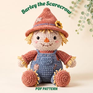 May include: A crochet scarecrow doll named Barley the Scarecrow, featuring a textured rust-colored hat with a small sunflower, blue overalls with patches, and yellow yarn straw accents at the sleeves and ankles. The text reads Barley the Scarecrow PDF PATTERN.