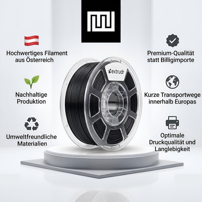 Peut inclure: Une bobine de filament pour imprimante 3D noire avec un cadre en plastique transparent, portant la marque extrudr sur l'&eacute;tiquette. La bobine est entour&eacute;e de texte et d'ic&ocirc;nes soulignant la production autrichienne et la durabilit&eacute;.