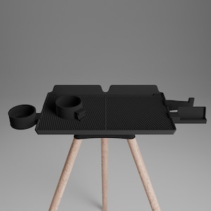 Peut inclure: Un plateau noir avec une surface textur&eacute;e, un porte-gobelet circulaire sur la gauche et un compartiment de rangement rectangulaire sur la droite, soutenu par trois pieds en bois clair. Le plateau pr&eacute;sente un motif en grille et une poign&eacute;e.